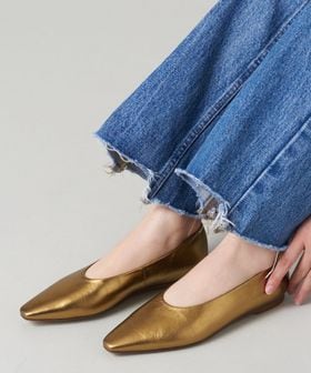 ゴールドのフラットシューズを履いている画像